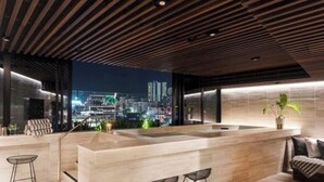 Ein modernes Interieur mit Kücheninsel, Sitzgelegenheit und Blick auf die Stadt.