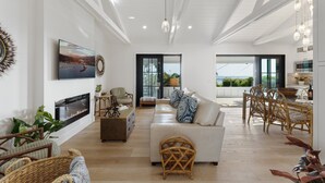 Amplia sala de estar con chimenea, asientos cómodos y un ventanal con vistas al exterior.