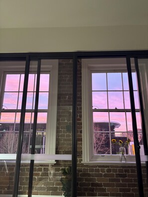 A room with two windows, a brick wall, and a view of a building with a dome structure. - Modern one bedroom apartment 10 min walk to Sydney CBD or harbour (Darlinghurst)