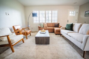 A living room with a sofa set, a coffee table, and a floor lamp.