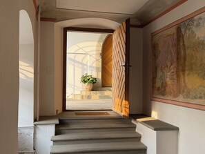 A staircase leading to a room with a large painting on the wall.