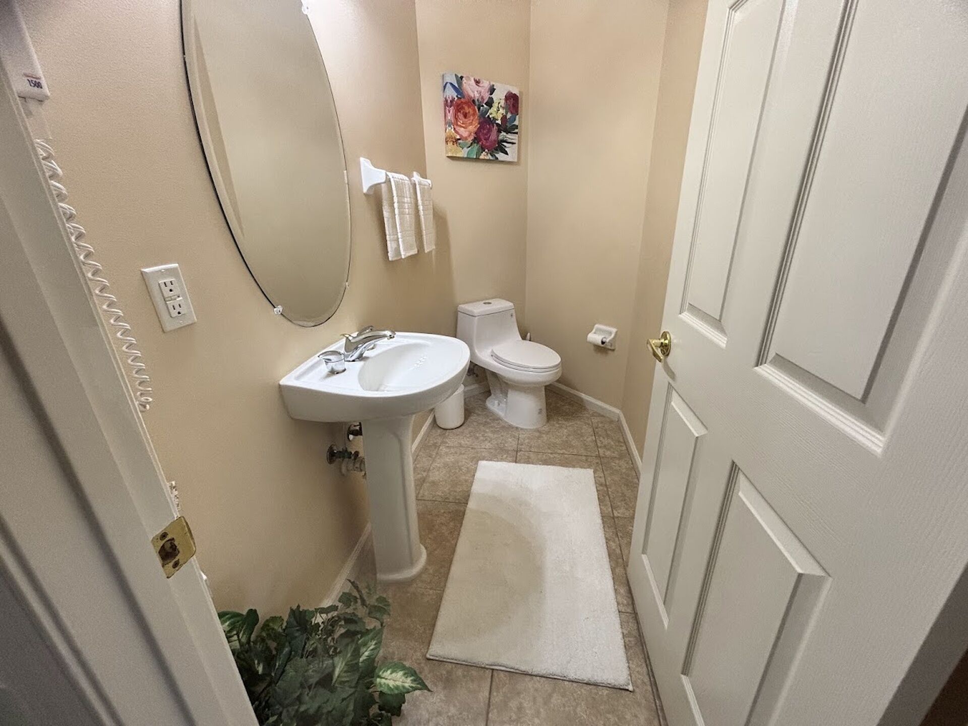 Une salle de bain avec un lavabo, des toilettes et une porte.