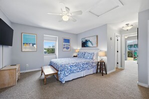 A bedroom with a bed, a desk, a chair, a ceiling fan, and artwork on the walls. - 3BR Duck cottage in Sound Sea, near the beach and Duck village. (Duck)