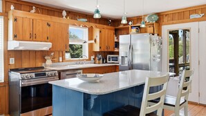 A kitchen with wooden cabinets, stainless steel appliances, a large island, and pendant lighting. - 3BR Duck cottage in Sound Sea, near the beach and Duck village. (Duck)
