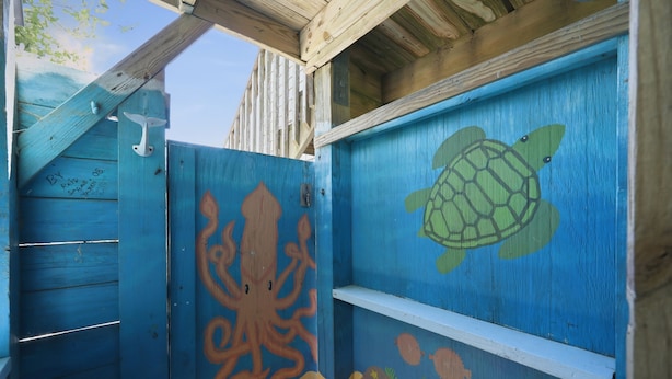 A wooden structure with painted marine life, including an octopus and a turtle, and a white shelf. - 3BR Duck cottage in Sound Sea, near the beach and Duck village. (Duck)