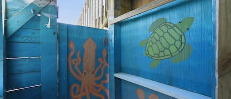 A wooden structure with painted marine life, including an octopus and a turtle, and a white shelf.