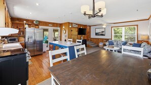 A spacious kitchen with a central island, wooden cabinetry, and a large refrigerator. - 3BR Duck cottage in Sound Sea, near the beach and Duck village. (Duck)