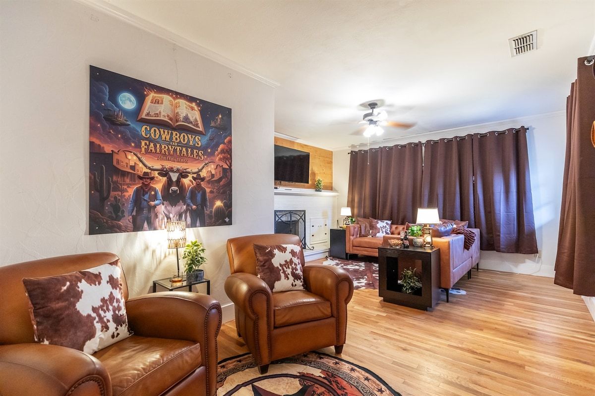 A living room with leather sofas, a fireplace, and a large poster on the wall.