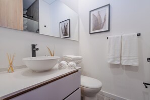 Een haardroger, handdoeken, zeep, toiletpapier