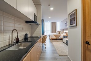 A modern kitchen with a black countertop, stainless steel sink, and wooden cabinets. - Luxury boutique suite 5 stars plus free parking (Bogotá, D.C.)