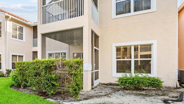 Un edifici residencial de dues plantes amb un balcó, una petita zona de jardí i una finestra visible.