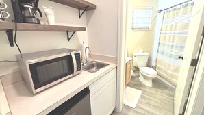 A compact kitchen with a microwave, sink, and a small countertop. - Right Direction Rentals Studio Villa 9970 (Port St. Lucie)