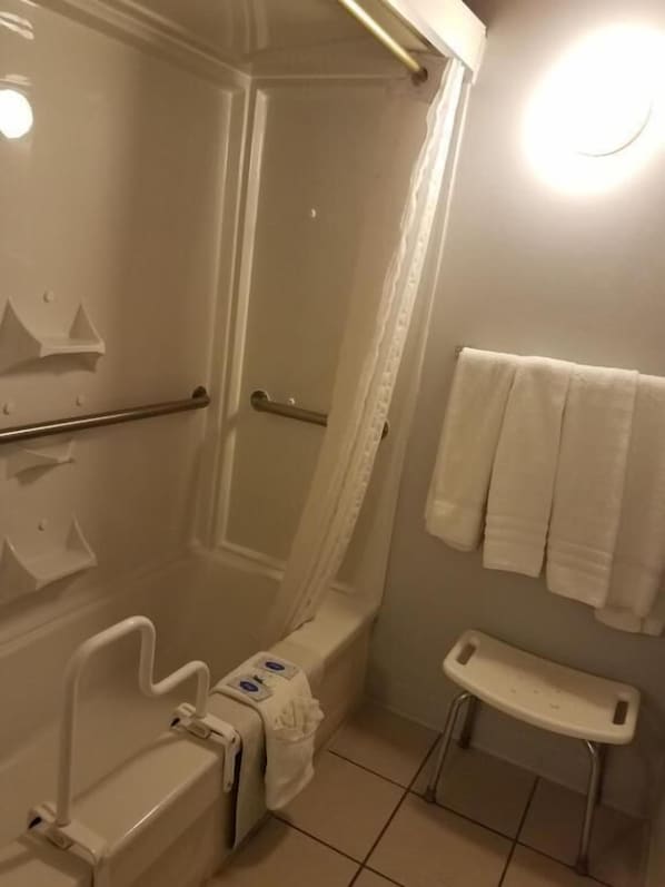 Kylpyhuone, jossa on suihku, wc ja tukikaiteet.