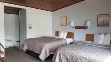 Ein Schlafzimmer mit zwei Betten, einer Holzbalkendecke und einem kleinen Tisch.