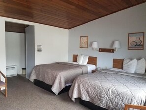 Ein Schlafzimmer mit zwei Betten, einer Holzbalkendecke und einem kleinen Tisch.