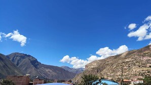 Un paysage montagneux avec un ciel dégagé, des bâtiments et une montagne imposante sur laquelle on peut voir l’inscription « 711 ».