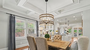 A dining area with a wooden table, upholstered chairs, a chandelier, and a view of the kitchen. - East Atlanta Retreat - Office + Backyard Oasis (Atlanta)
