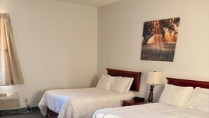 Habitación de hotel con dos camas, un calentador en la pared, una lámpara y un cuadro.