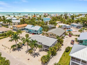 A coastal residential area with houses, palm trees, and a beach. - Beachside Canal Retreat with Coastal Charm -  The Shore at Ocean Palms Retreat - Roelens (Fort Myers Beach)