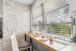 Ein Frühstückstisch mit Stuhl und Fenster mit Jalousien.