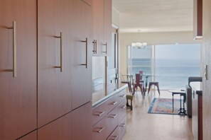 Eine moderne Küche mit Holzschränken und Blick auf den Ozean.