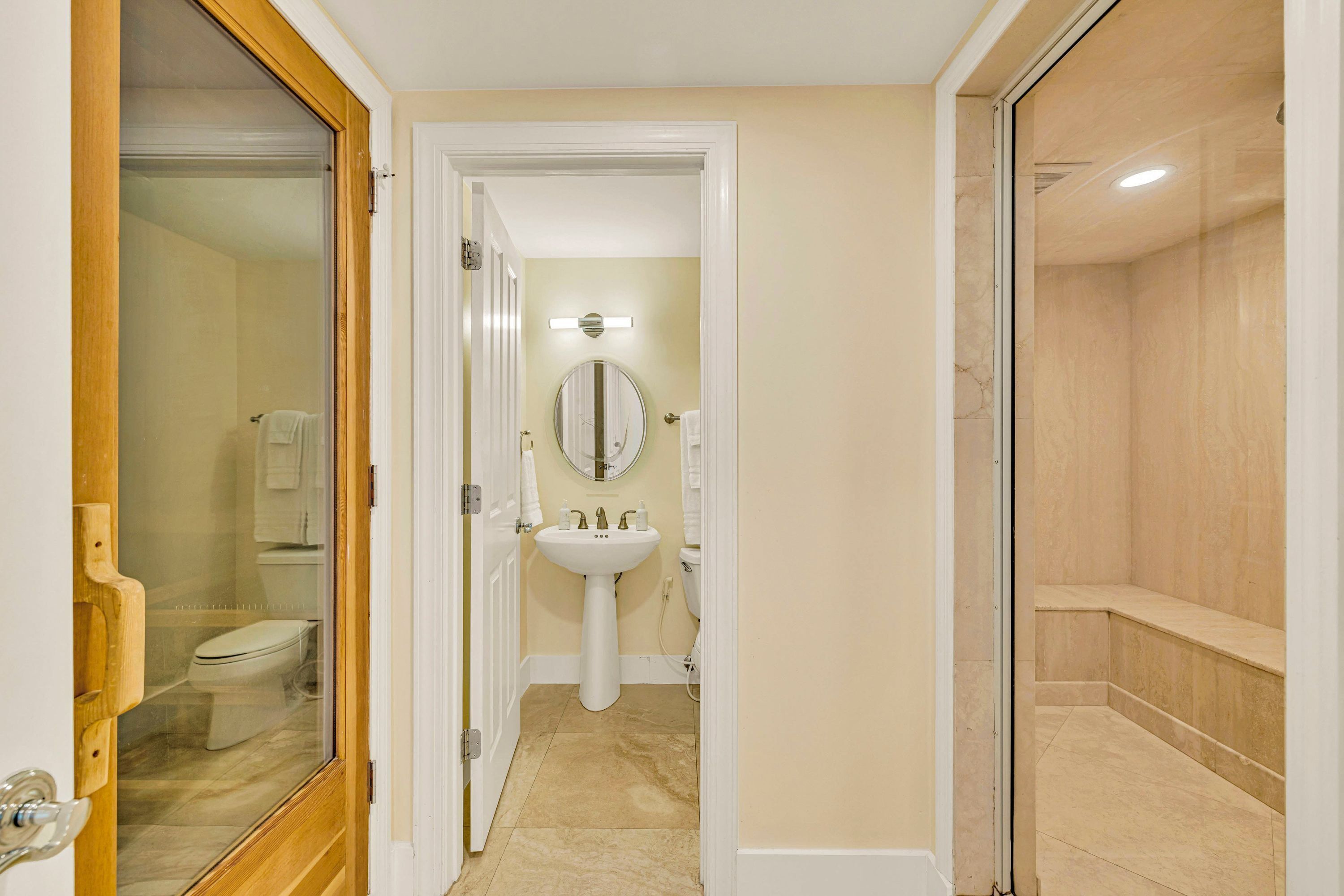 Une salle de bain équipée de toilettes, d’un lavabo, d’un miroir et d’une douche.