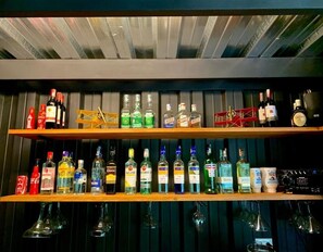 A bar with shelves of various liquor bottles and glasses. - Ecohotel Refugio del Bosque (La Mesa)