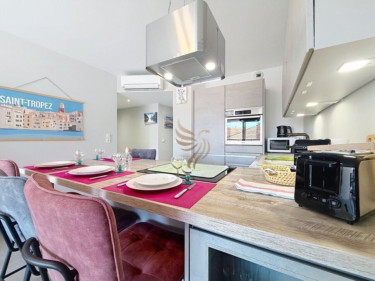 A dining area with a table set for four, a microwave, and a toaster on the counter.