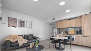 A modern living room with a sofa, coffee table, and artwork on the wall. - 501 - 3508 (Miami)