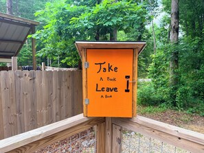 A wooden book exchange box with a sign that says 'Take A Book Leave A Book.'