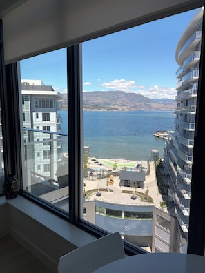 A high-rise hotel with a view of a lake and mountains.