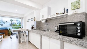 A modern kitchen with a built-in oven, a sink, and a dining area with a view. - Surf & Work Retreat - Private Pool - Fast WiFi (Punta Hermosa)