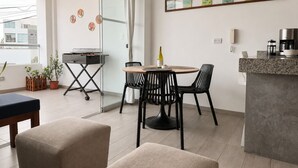 A modern kitchen with a round dining table, black chairs, a coffee machine, and a wine bottle. - Surf & Work Retreat - Private Pool - Fast WiFi (Punta Hermosa)