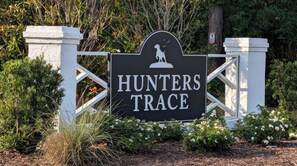 Un letrero con la inscripción 'HUNTERS TRACE' y la silueta de un perro.