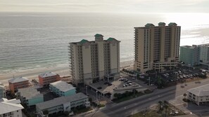 A coastal hotel with multiple high-rise buildings, a parking area, and a beach view. - Gulf Front Beach Chic Crystal Shores 806 Sleeps 6 (Gulf Shores)