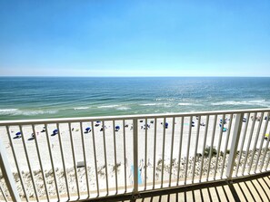 A beach view from a balcony with a railing, sandy beach, and ocean. - Newly Refreshed Gulf Front 2 King Condo, Sleeps 6 (Gulf Shores)