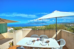 A table set for two with a view of the sea and mountains in the background. - The Terrace of the Gulf of Ajaccio - Welkeys (Pietrosella)