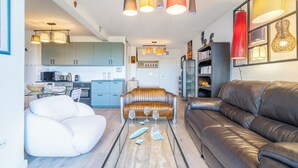 Un salon moderne avec une table basse en verre, des canapés en cuir et des luminaires suspendus.