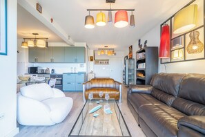 Ein modernes Wohnzimmer mit Glastisch, Ledersofas und Pendelleuchten.