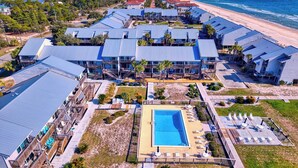 Ein Resort mit mehreren Gebäuden, einem Schwimmbad und Blick auf den Strand.