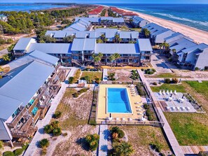 Ein Resort mit mehreren Gebäuden, einem Schwimmbad und Blick auf den Strand.