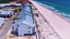 Un hôtel situé sur la côte, composé de plusieurs bâtiments, avec une plage et une vue sur l’océan.