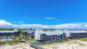 Un hôtel situé sur la côte, composé de plusieurs bâtiments, doté d’une piscine et offrant une vue sur la plage.