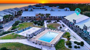 Un resort con diversi edifici, una piscina e vista sul tramonto.