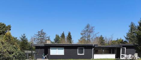 A two-story house with a front porch, a garage, and a small yard.