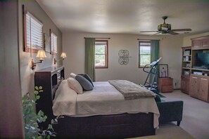 Une chambre à coucher avec un lit, un tapis de course et un téléviseur.