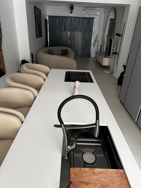 Una cocina moderna con estufa integrada, hervidor y tabla de cortar.
