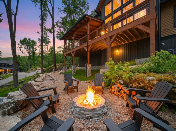 A lodge with a fire pit, outdoor seating, and a covered deck. - Luxury Mountain Retreat in Eagles Nest (Banner Elk)