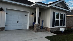 Ein Wohnhaus mit Garage, einer Veranda und einem Ziegelkeller.