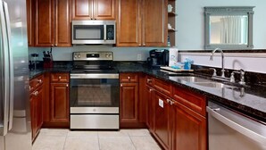 Una cucina moderna con mobili in legno, elettrodomestici in acciaio inossidabile e un piano di lavoro in granito.